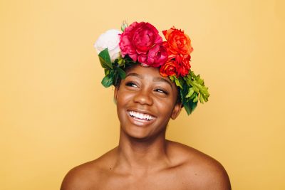 Frau mit Blumenmütze lächelt