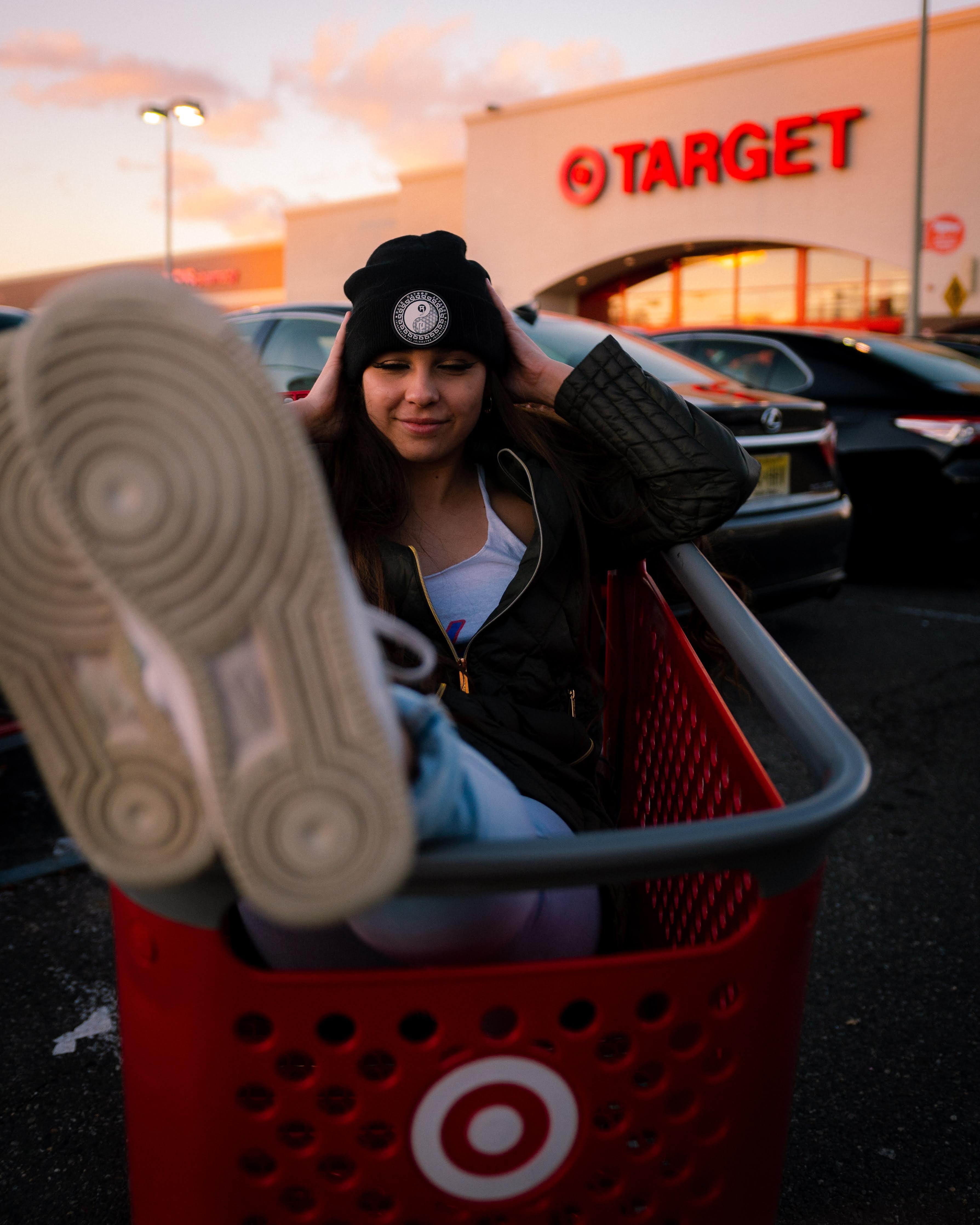 Eine Frau sitzt in einem Target Einkaufswagen und im Hintergrund befindet sich ein Target Einkaufscenter