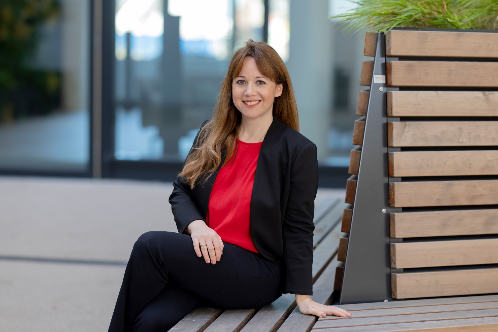 Veronika Birkheim Gründerin von PEOPLETALENT lächelnd auf einer Bank sitzend.