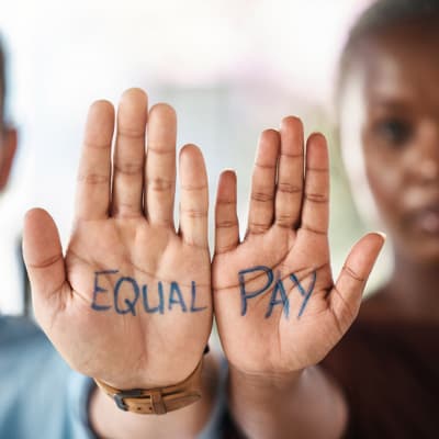 2 Personen mit der Aufschrift Equal Pay auf der Hand