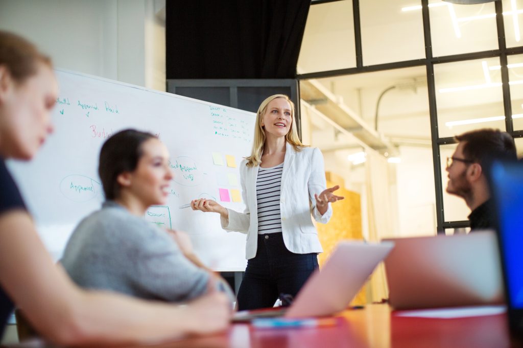 Business Frau hält Vortrag Eine Frau steht vor einem Paper Chart und hält eine Präsentation.